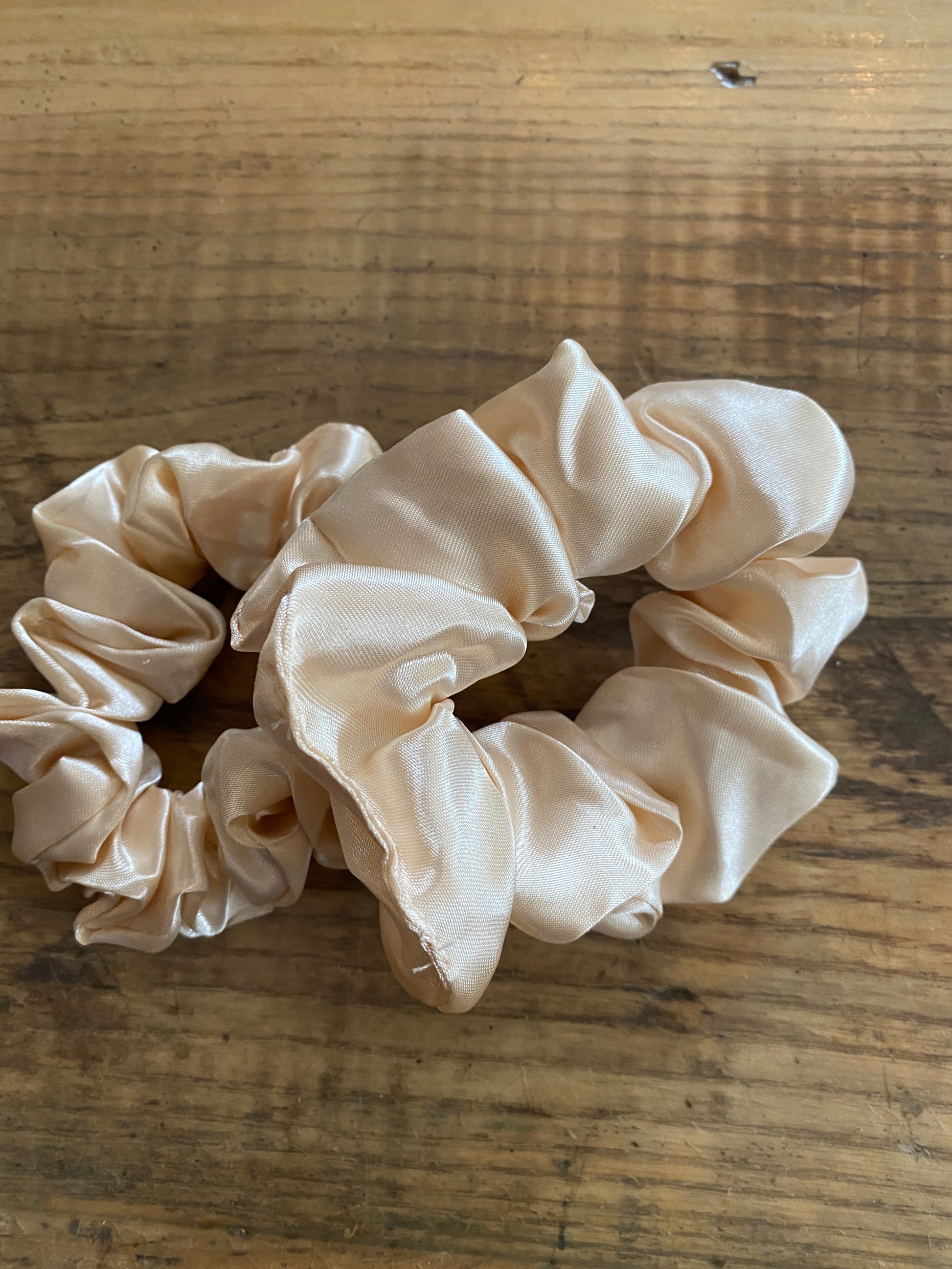 Cream coloured satin scrunchy hair tie.